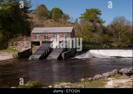 Under blue sky, Linton Turbine House on River Wharfe, restored hydroelectric plant supplying power from water - Grassington, Yorkshire Dales, England. Stock Photo