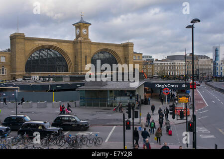 King's Cross railway station - a view of its impressive facade with consruction work, busy road junction & pedestrians in foreground - London, GB, UK. Stock Photo