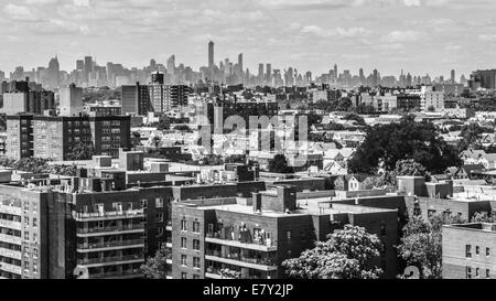 Aerial view of the buildings and streets of Rego Park area in Queens, with the skyscrapers of the city of Manhattan in the far b Stock Photo