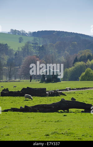 View across beautiful rural parkland of man viewing Henry Moore sculpture, 'Large Two Forms' 1966-69, at  The Yorkshire Sculpture Park, England, UK. Stock Photo