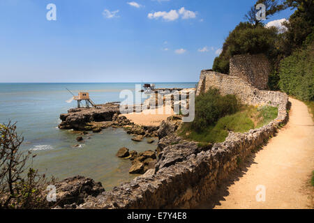 The coastal path alongside traditional fisherman huts on stilts with carrelets nets on the coast of Charente Maritime France. Stock Photo