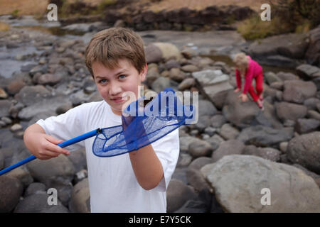 Young boy or child catching crab on holiday relaxing at South African Drakensburg mountain stream or river Stock Photo