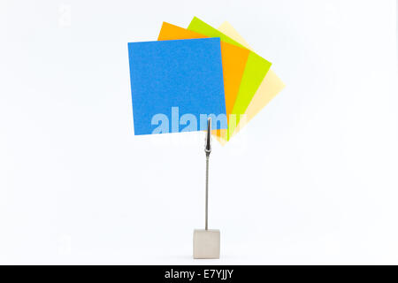 Paperclip holds sticky notes in yellow,green,orange and blue. Stock Photo
