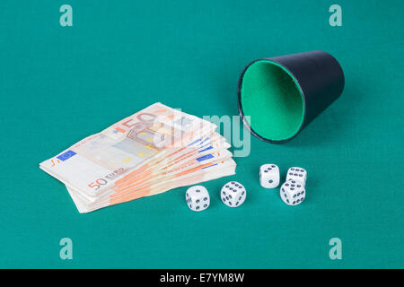 Dices with cup and euros on a green cloth Stock Photo