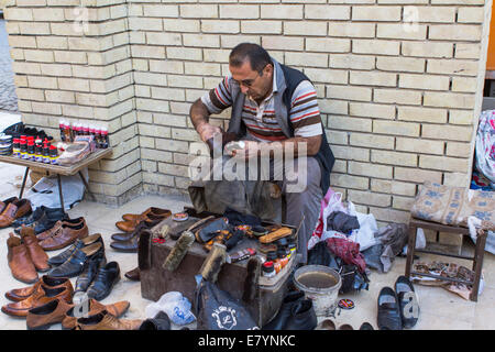 A Kurdish shoe shiner at work at the bazaar, in Erbil (Arbil), Iraqi Kurdistan province, Iraq. Stock Photo