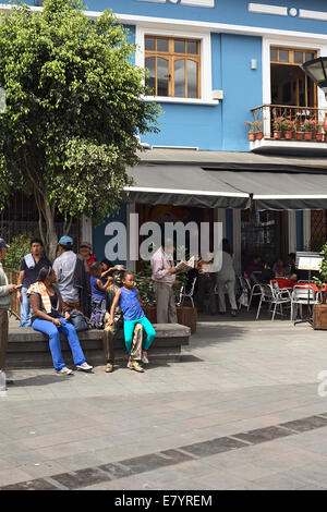People sitting and standing on Plaza del Teatro (Theater Square) in the city center in Quito, Ecuador Stock Photo