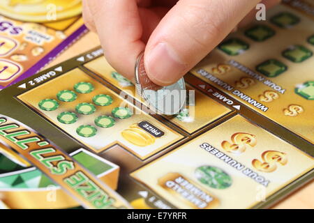 Coquitlam BC Canada - June 15, 2014 : Woman scratching lottery ticket called Monopoly. It's published by BC Lottery Corporation Stock Photo