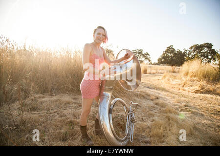 Young woman posing with sousaphone on field Stock Photo