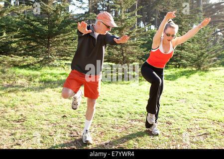 Man and woman doing exercises outdoors Stock Photo