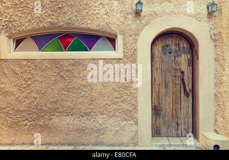 wall with wooden door and stained glass windows Stock Photo