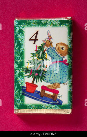 Count down to Christmas with individual advent chocolate bars isolated on red background - calendar day 4 of set of 24 Stock Photo