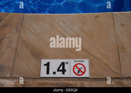 Information about water depth and a no-diving warning at the edge of a swimming pool in Kingdom of Bahrain Stock Photo