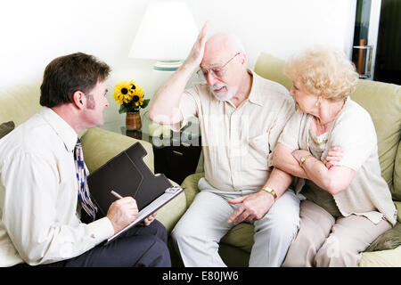 Senior couple in therapy.  Husband is feeling guilty. Stock Photo
