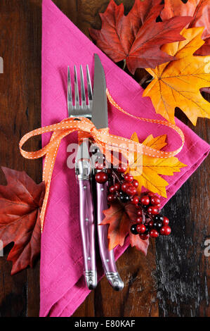 Bright and colorful pink, orange and black modern Thanksgiving or Halloween autumn fall place setting on recycled wood table Stock Photo