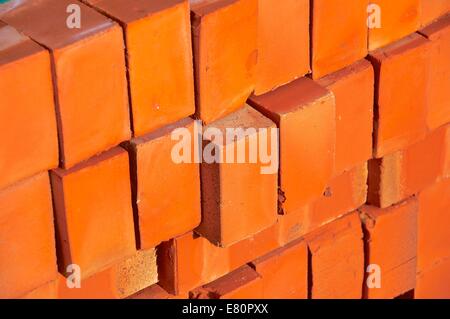 A pile of new bricks at construction site sitting on wooden flat Stock ...