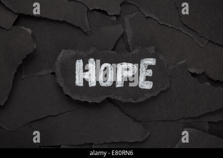 Hope. Torn pieces of black paper and the word 'Hope'. Black and White. Close-up. Stock Photo