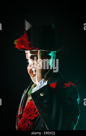 A young man is dressed in a wizard hat and spike-tail Stock Photo