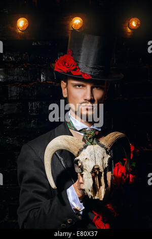 The young man is wizard holds the old goat skull Stock Photo