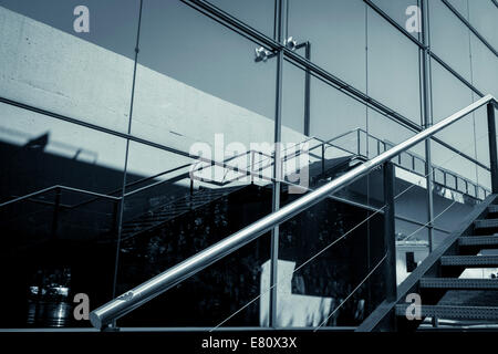 detail of a glass facade with reflection and handrail Stock Photo