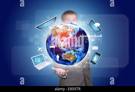 Businessman in suit hold Earth with electronics, graphs and icons Stock Photo