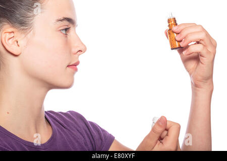 woman is examine a bottle of homeopathic medicine, isolated on white Stock Photo