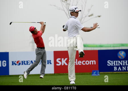 Incheon, South Korea. 28th Sep, 2014. Guan Tianlang (R) of China warms up during the golf men's team match at the 17th Asian Games in Incheon, South Korea, Sept. 28, 2014. China ranked 4th. Credit:  Gao Jianjun/Xinhua/Alamy Live News Stock Photo