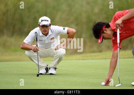 Incheon, South Korea. 28th Sep, 2014. Bai Zhengkai (L) of China competes during the golf men's team match at the 17th Asian Games in Incheon, South Korea, Sept. 28, 2014. China ranked 4th. Credit:  Gao Jianjun/Xinhua/Alamy Live News Stock Photo