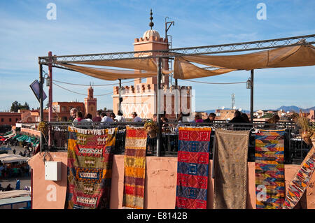 Horizontal view of people at a rooftop cafe enjoying the views across Place Jemaa el-Fnaa in Marrakech. Stock Photo