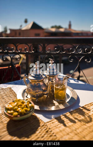 Vertical close up of traditional mint tea and olives served overlooking Place Jemaa el-Fnaa in Marrakech. Stock Photo