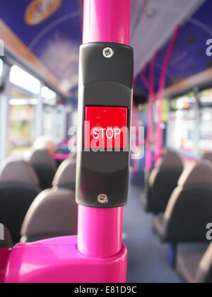 A stop button on board a bus with the word stop on braille in one corner Stock Photo