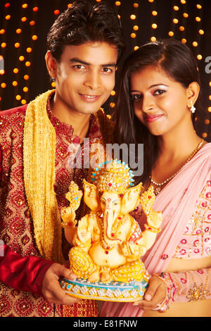 indian couple diwali Festival standing Ganpati Statue Stock Photo