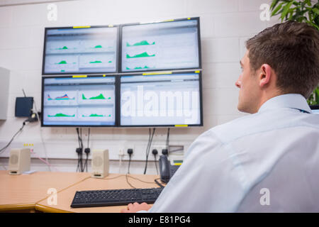 Serious technician looking at computer screen Stock Photo