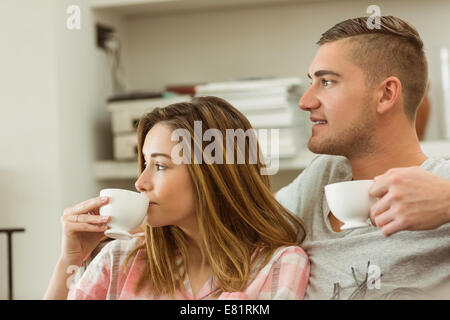 Cute couple relaxing on couch with coffee Stock Photo