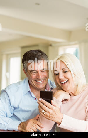 Happy mature couple looking at smartphone together Stock Photo
