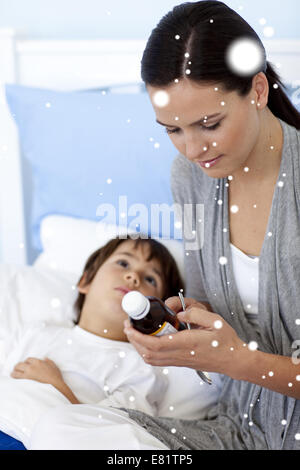 Composite image of mother giving her son syrup Stock Photo