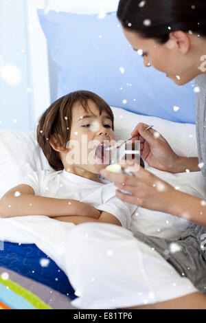 Composite image of mother giving her son syrup Stock Photo