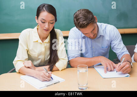 Focused business people taking notes during presentation Stock Photo