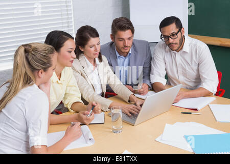 Focused business team having a meeting using laptop Stock Photo