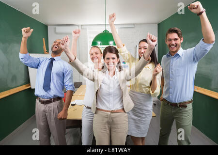 Excited business team cheering at camera Stock Photo