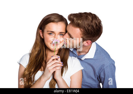 Man kissing woman as she holds flower Stock Photo