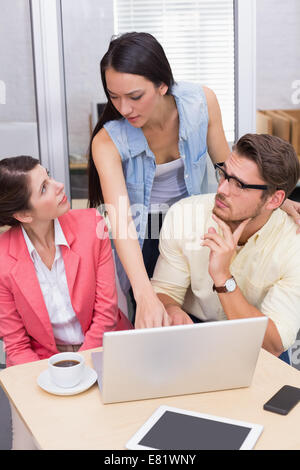 Thoughtful business team using laptop and having coffee Stock Photo
