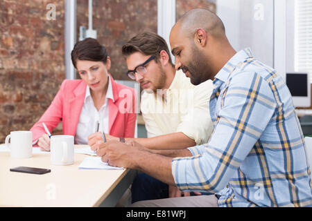 Focused business people taking down important notes Stock Photo