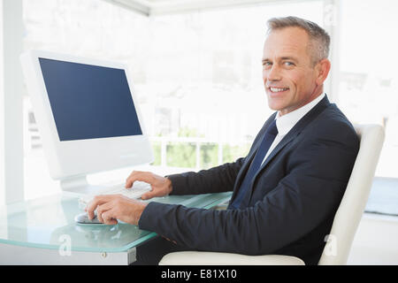A smiling businessman uses his computer Stock Photo