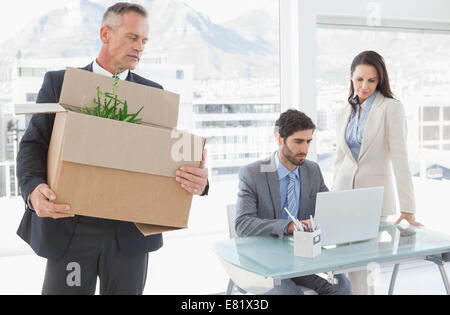 Sad businessman carrying a box Stock Photo
