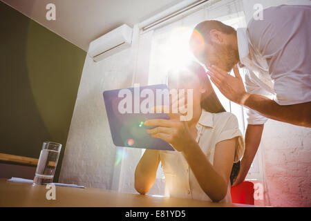 Sharing secrets while using digital tablet Stock Photo