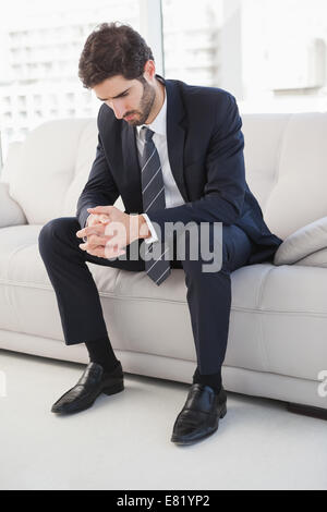 Nervous businessman sitting on couch Stock Photo