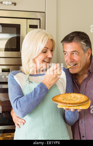 Happy mature blonde feeding pie to husband Stock Photo - Alamy