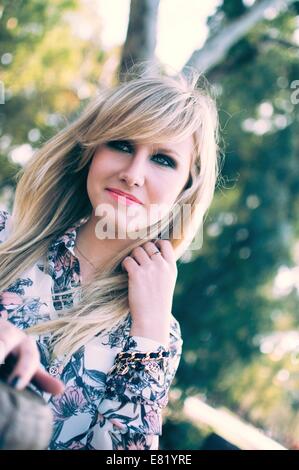 Young female blond model outdoors alone in a park Stock Photo