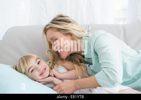 Beautiful mother and daughter lying on the couch Stock Photo