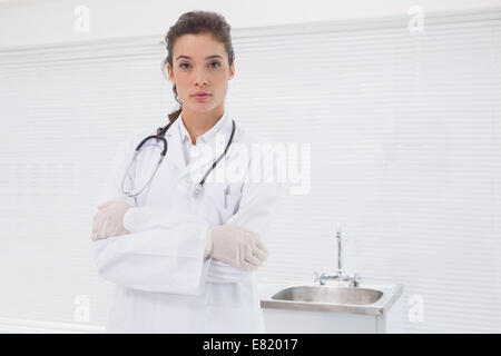 Concentrated doctor standing with stethoscope Stock Photo